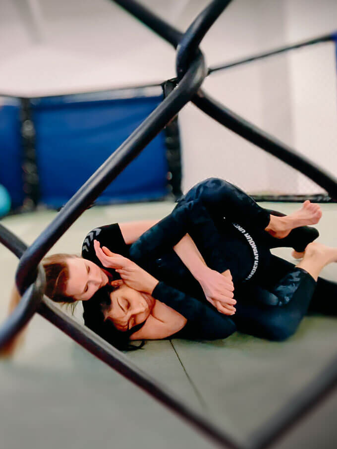 Zwei Frauen trainieren BJJ im MMA Cage im Combat Club Cologne